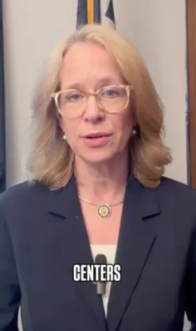 Screenshot of Kelly Morrison standing in front of Minnesota flag